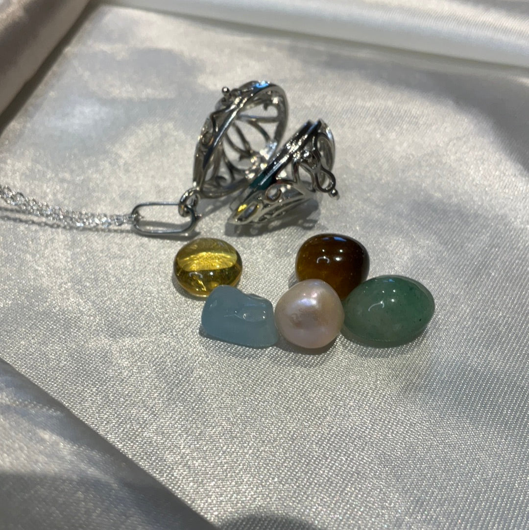 Silver plated cage pendant on silver plated chain. Cage can open to store small crystals within. Comes with crystal and pearl selection.
