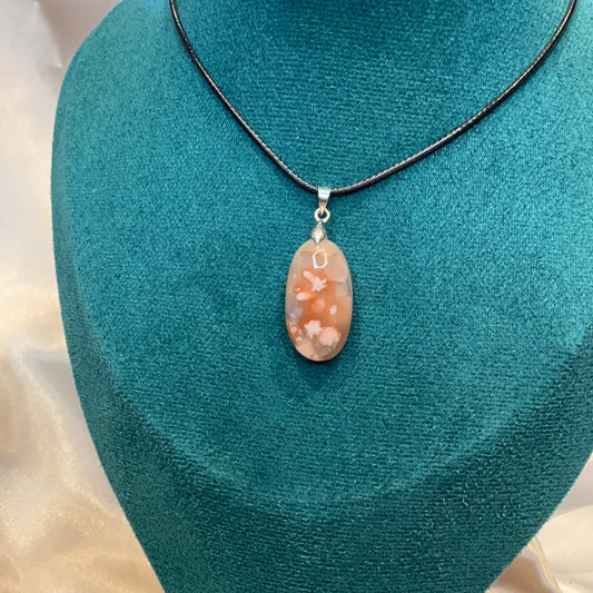 Carnelian flower agate crystal oval pendant on black cord