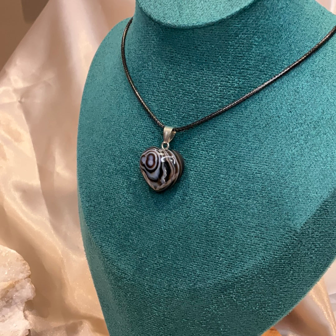 Banded striped Agate heart crystal pendant on black cord.